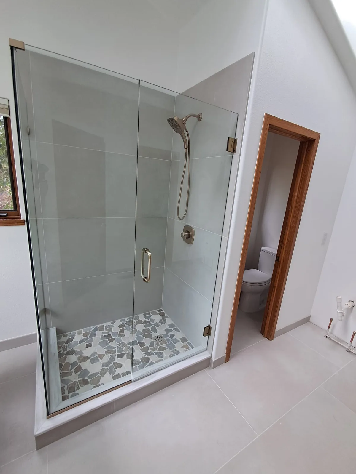 Frameless glass shower with flat pebble floor